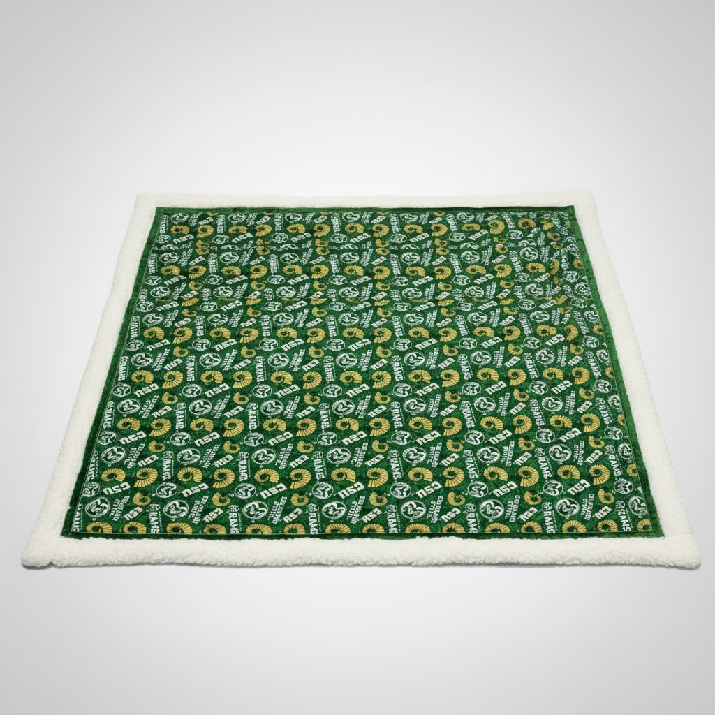 Green patterned blanket with white border on a light gray background