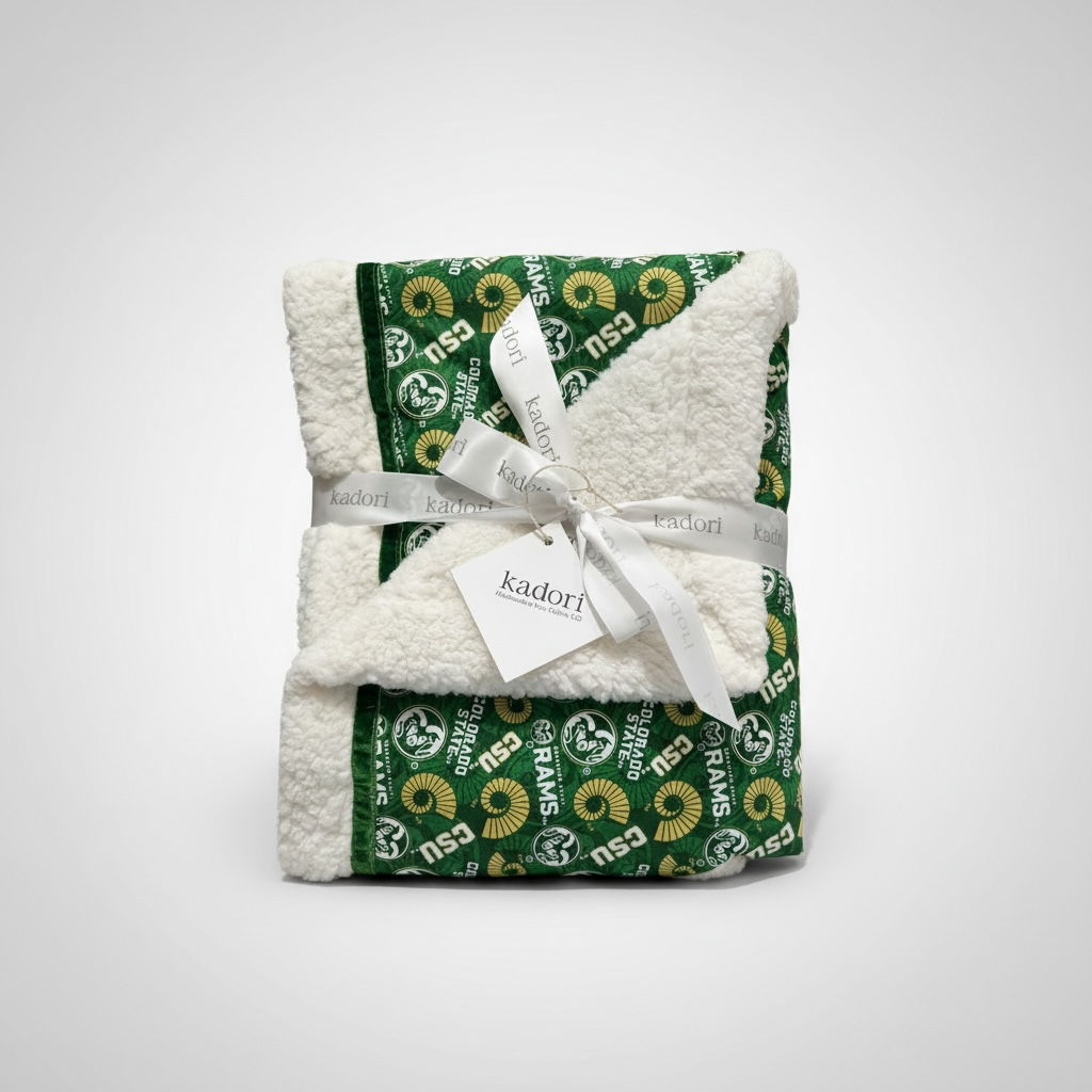 Folded green and white blanket with a visible brand tag on a white background