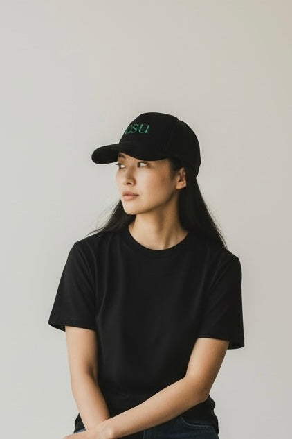 Person wearing a black cap and t-shirt against a plain background