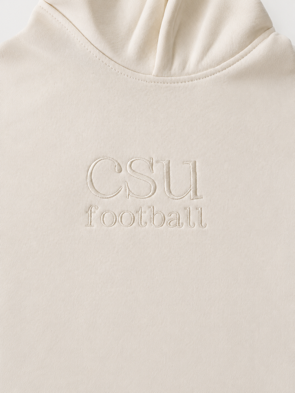 Close-up of a cream-colored hoodie with 'CSU football' embroidered on the chest.