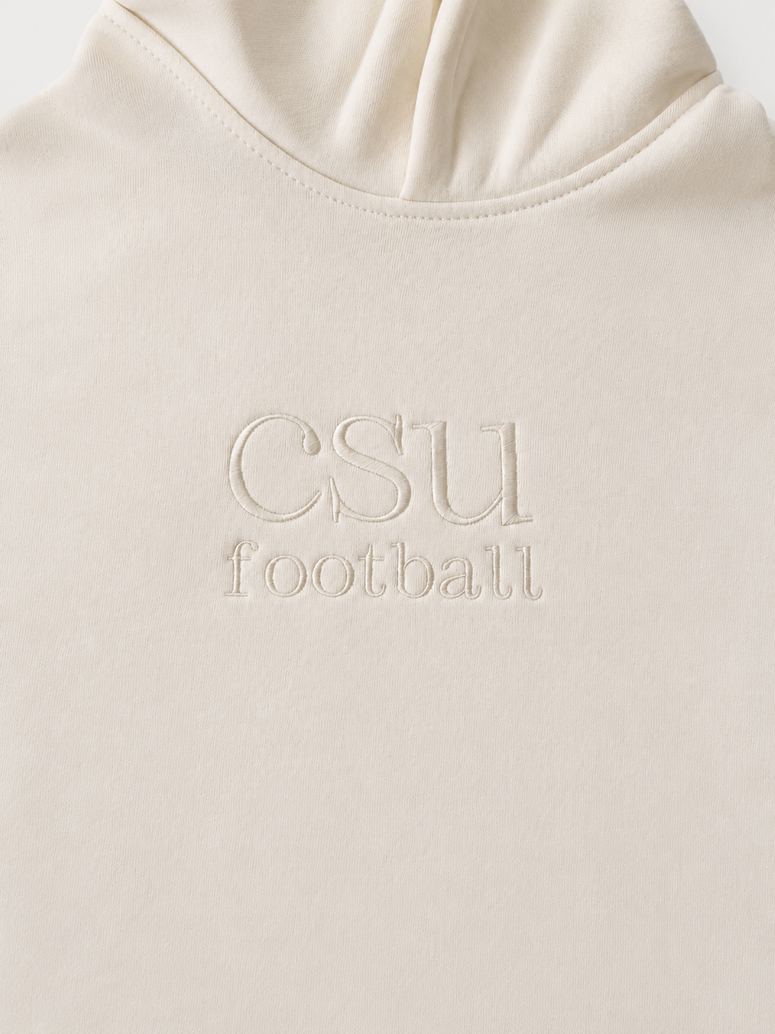 Close-up of a cream-colored hoodie with 'CSU football' embroidered on the chest.