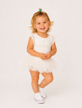 A toddler girl wearing a white tutu dress with lace flutter sleeves and the name 'Evelyn' printed on the chest, standing against a plain white studio background.